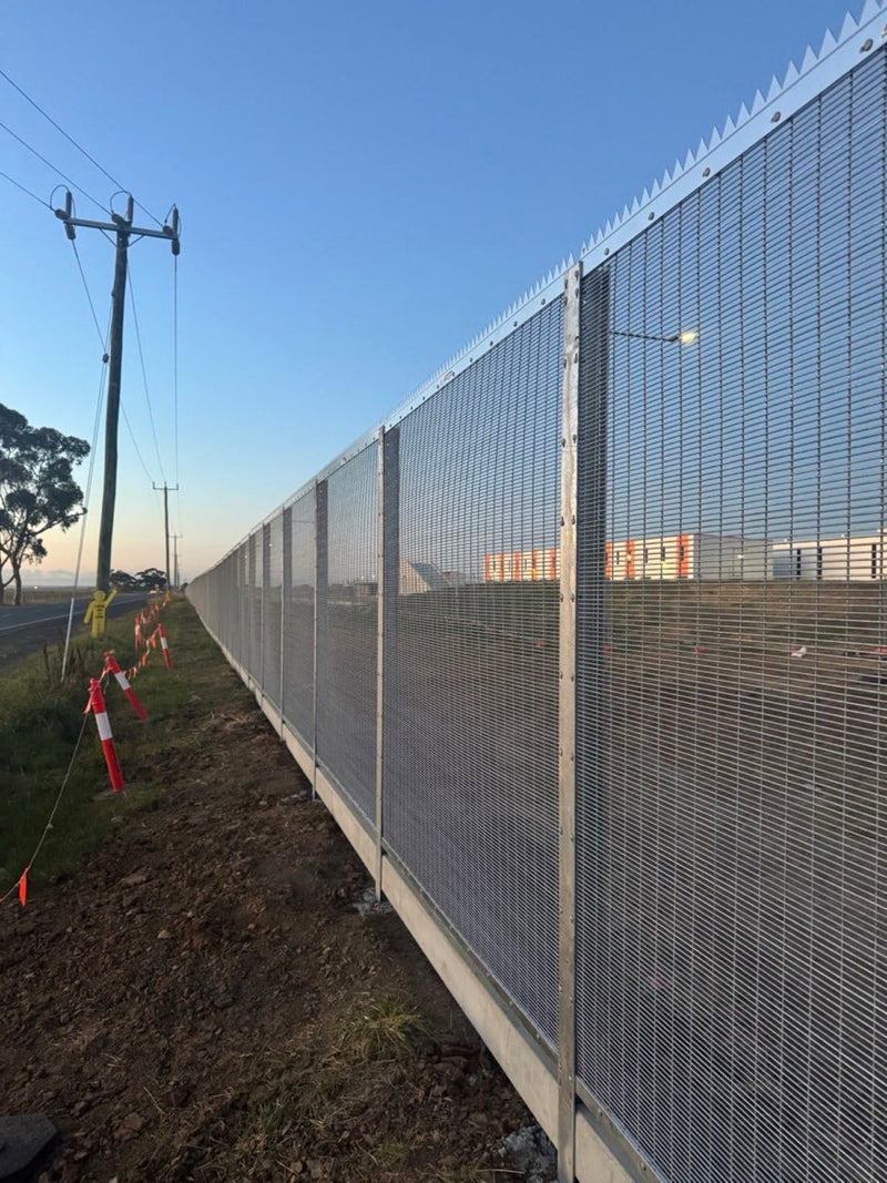Long run of anti-climb spikes along a commercial security fence