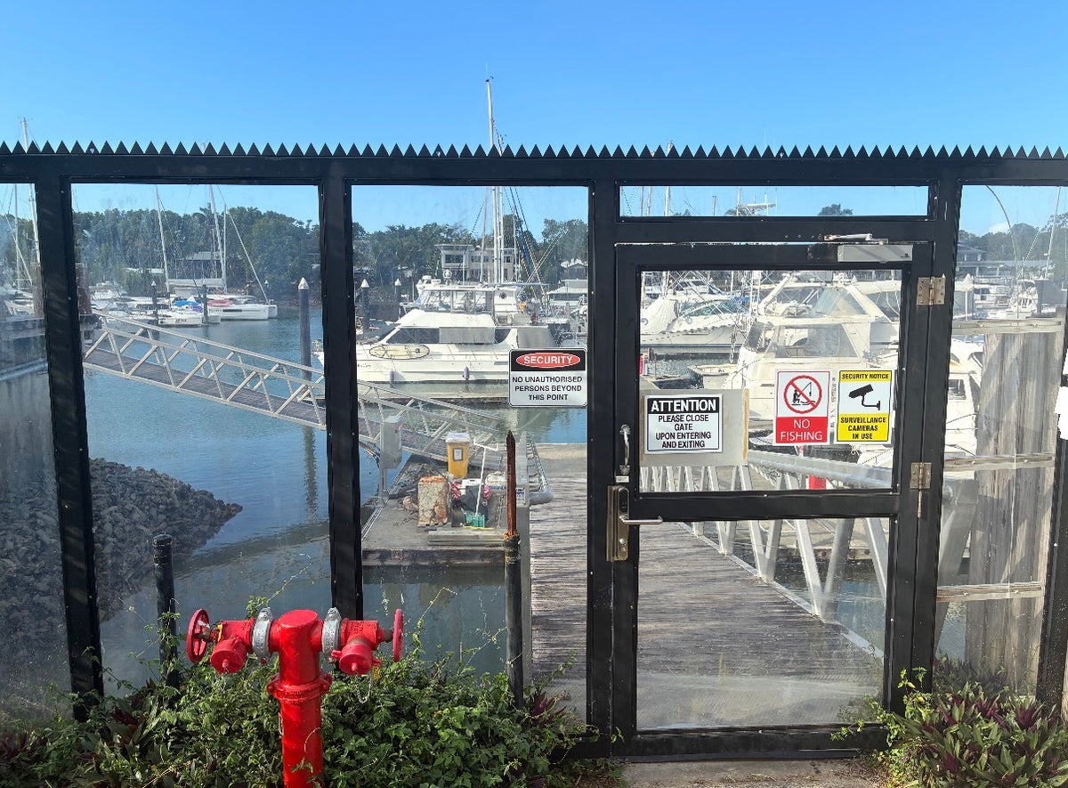 Anti climb spikes fitted along the top of a glass marina access gate